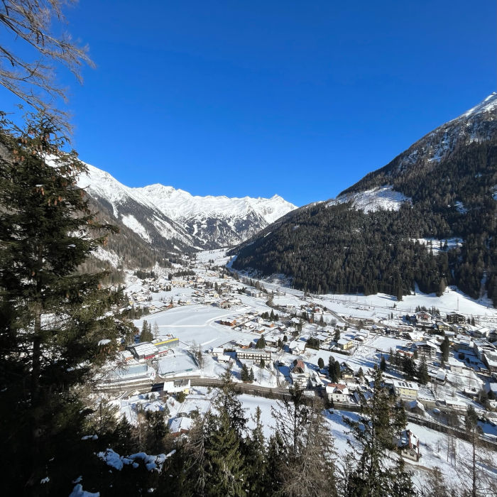 Widok na górska wioskę Mallnitz z Margaretenpavillon na Winklerpalfen. W tle teren narciarski Gopass Ankogel należący do Tatry Mountain Resorts (TMR) w najjaśniejszym słońcu.